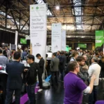 Crowded tech conference floor with people networking and banners for WeChat Developer Challenge and Extreme Tech Pavilion.