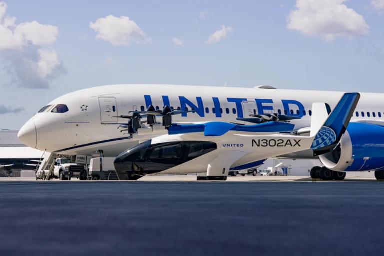 Small aircraft N302AX parked in front of a large United airplane on an airport tarmac under a partly cloudy sky.