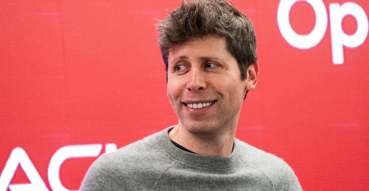 Person smiling in front of a red background with partial white text visible.