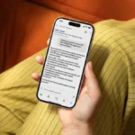 Person holding a smartphone displaying a message from Alexa for Shopping about verifying a suspicious OTP message.