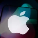 Apple logo on a smartphone screen with colorful blurred lights in the background.