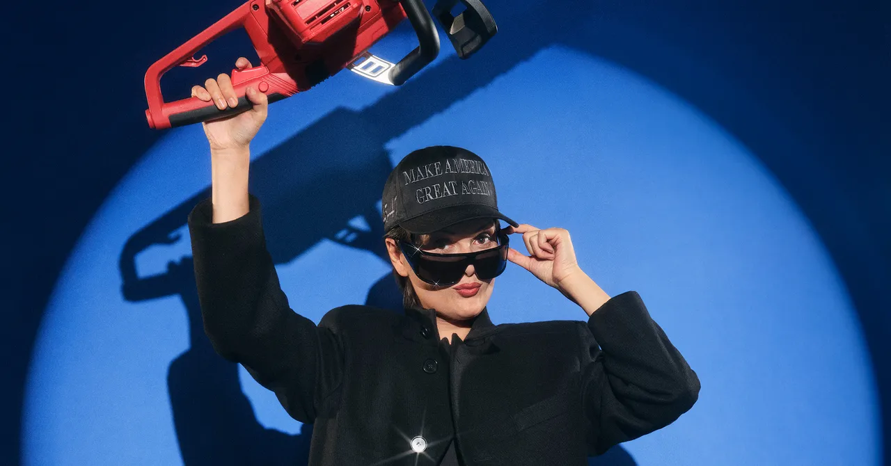 Person wearing a dark coat, cap with text, and sunglasses holds a red chainsaw against a blue background.