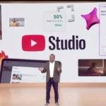 Presenter on stage in front of a YouTube Studio screen with AI tool graphics and video thumbnails.