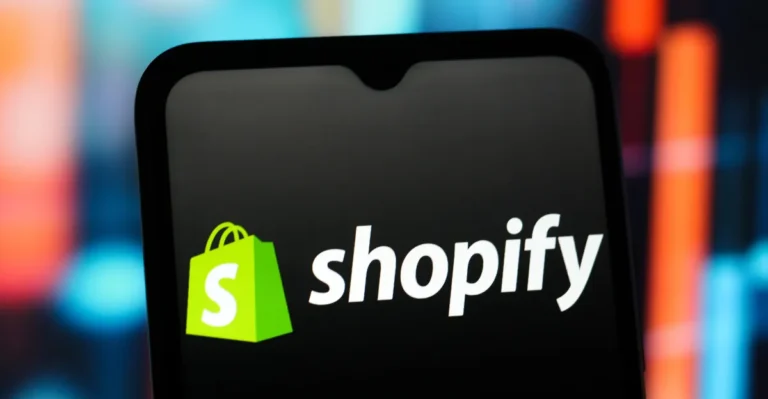 Shopify logo displayed on a smartphone screen with a colorful blurred background.