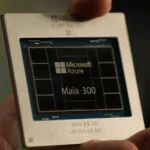 Hand holding a chip labeled Microsoft Azure Maia 300, with a blurred background.