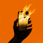 Hand holding a smartphone with flames emerging from the screen against an orange background
