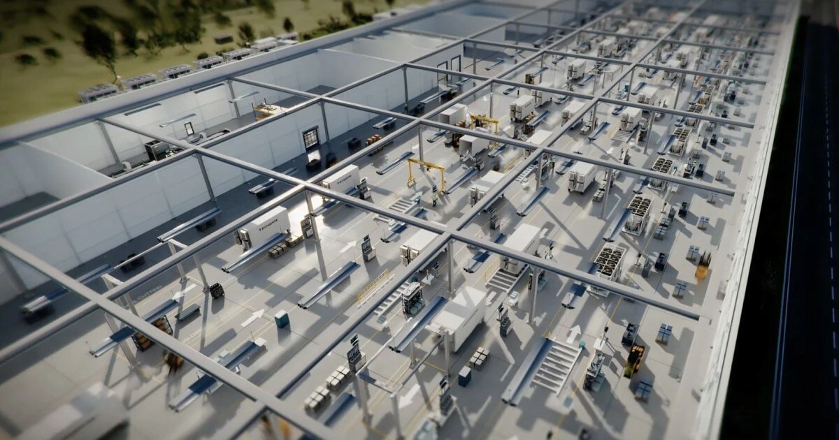 Interior of a large industrial facility with modular units, machinery, and overhead cranes, viewed from above.