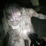 Grotesque creature lunges towards camera in dimly lit room, hand holding a gun aimed at it, wires visible in background