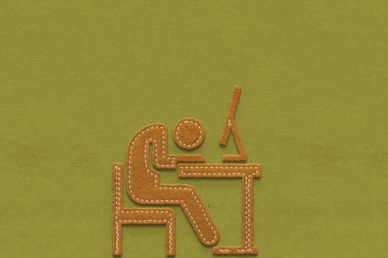 Brown felt figure slumped over a desk with a computer on an olive green background.
