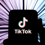 TikTok logo on a smartphone screen with a dynamic, radial blur background effect.