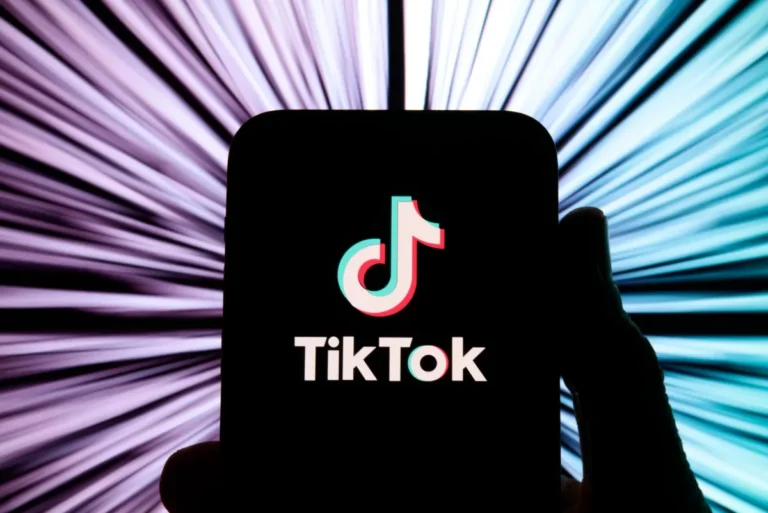 TikTok logo on a smartphone screen with a dynamic, radial blur background effect.