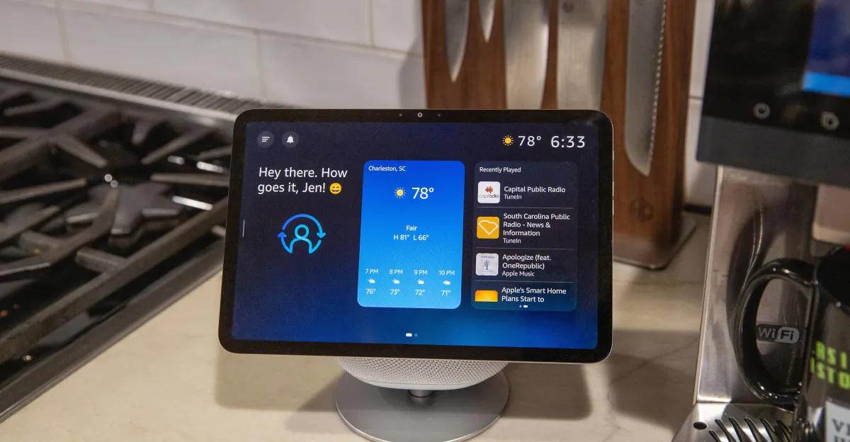 Echo Show displaying weather, time, and recently played media in a modern kitchen setting.