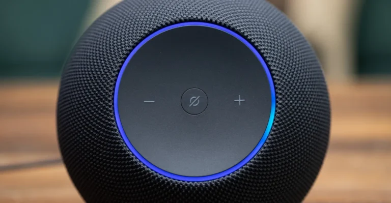 Close-up of a black Amazon Echo speaker with volume controls and a glowing blue ring on top.
