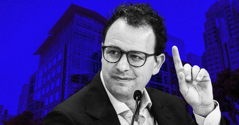 Man in glasses speaking with raised finger, microphone in front, urban building backdrop, blue-toned image.