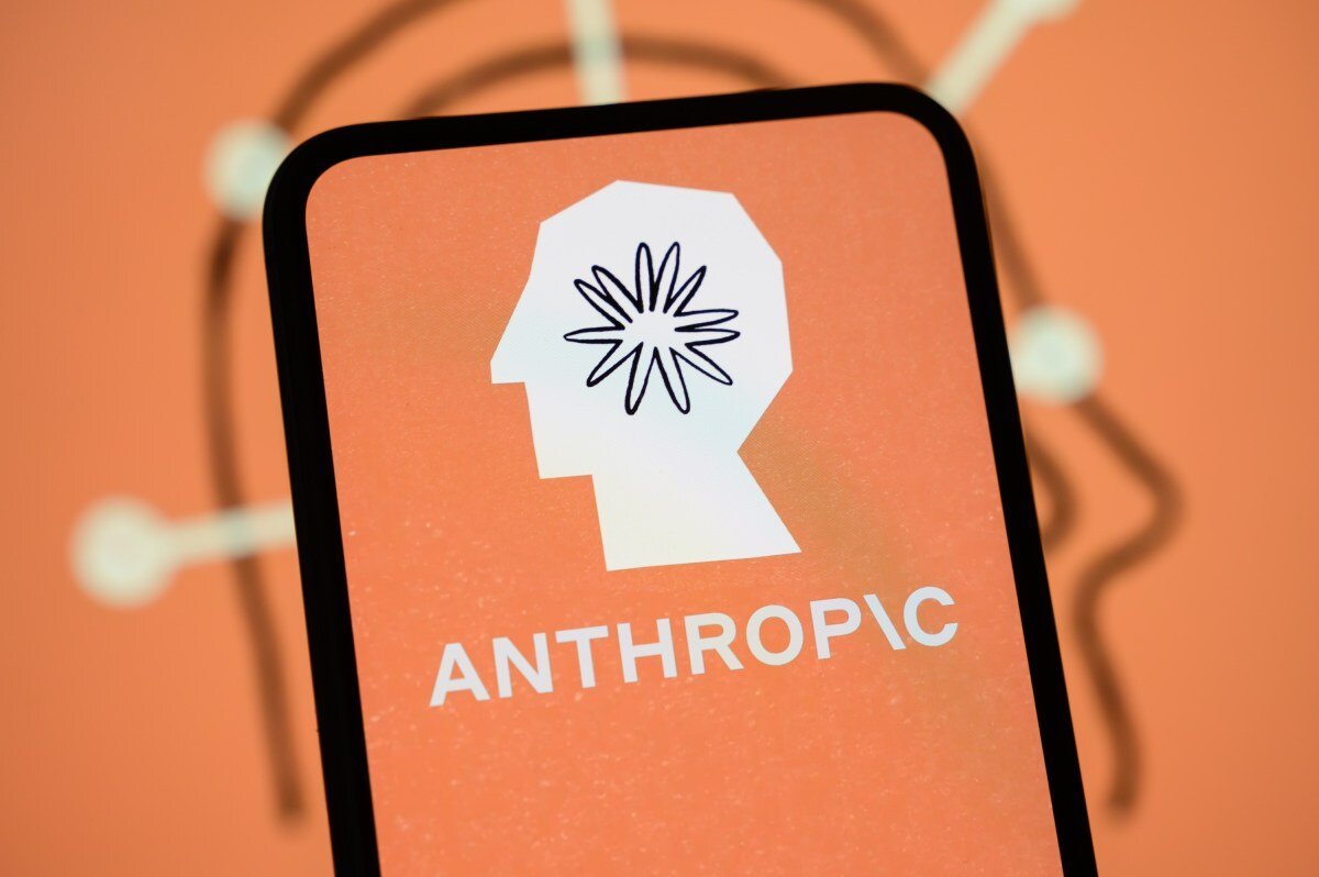 Smartphone displaying Anthropic logo with a stylized head and starburst on an orange background.