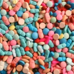 Assorted colorful pills and tablets scattered randomly in a close-up view.