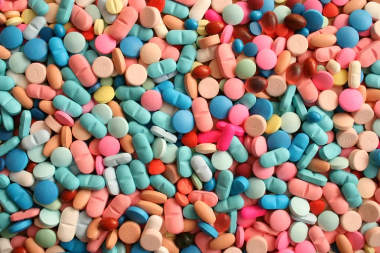 Assorted colorful pills and tablets scattered randomly in a close-up view.