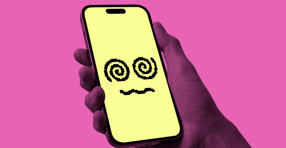 Hand holding a smartphone with a yellow screen displaying a pixelated face with spiral eyes, pink background.