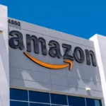 Amazon logo on a gray building facade with address number 4550 against a clear blue sky.