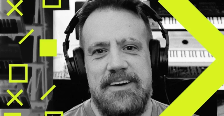 Man wearing headphones, smiling, with abstract yellow geometric shapes and blurred equipment in the background.
