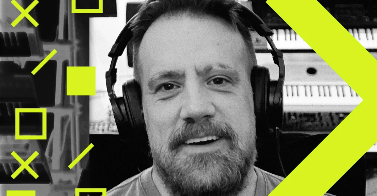 Man wearing headphones, smiling, with abstract yellow geometric shapes and blurred equipment in the background.