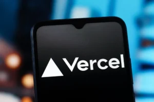 Smartphone screen displaying the Vercel logo with a triangular icon, blurred blue background.