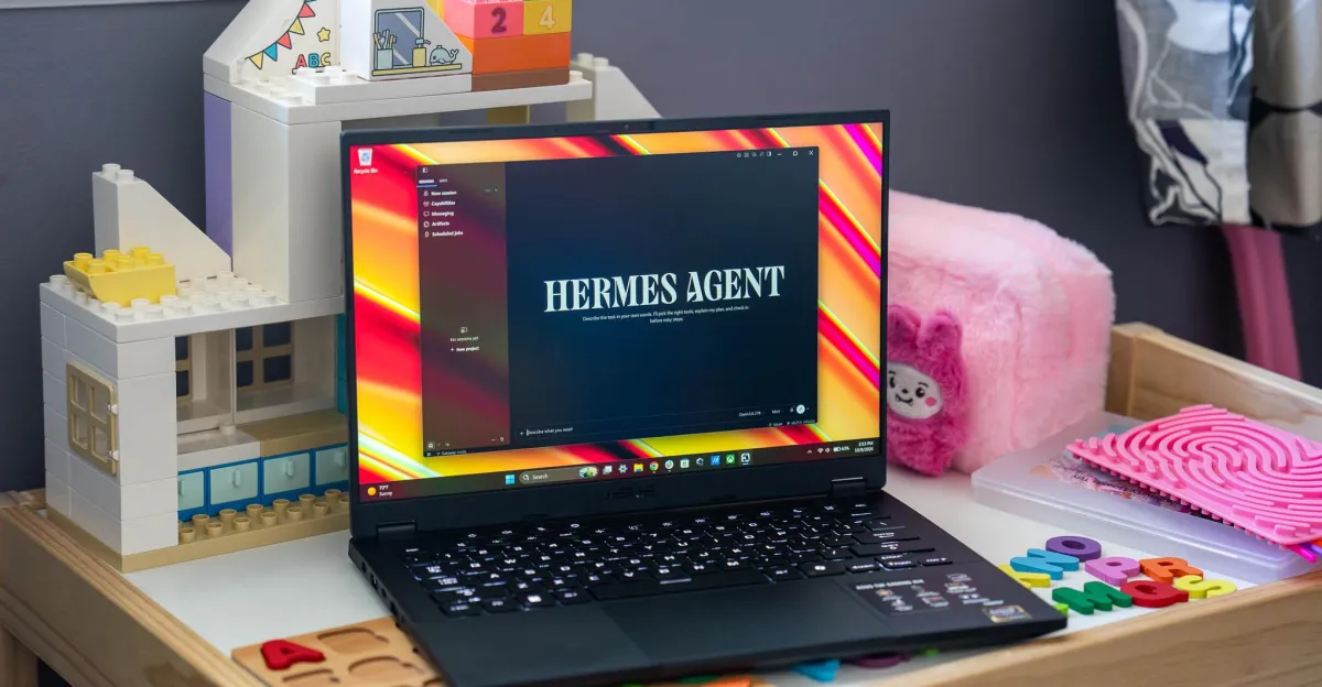 Laptop displaying "Hermes Agent" software on screen, surrounded by toy blocks and educational items on a desk.