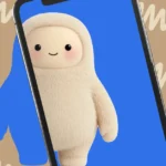 Cute, plush character on a smartphone screen with a blue background; wavy beige pattern in the surrounding area.