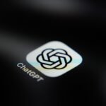 ChatGPT app icon on a dark screen, displaying a logo with interlocking shapes and text "ChatGPT" below.