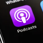 Close-up of a smartphone screen showing the Apple Podcasts app icon next to the App Store icon.