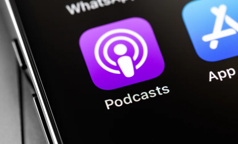 Close-up of a smartphone screen showing the Apple Podcasts app icon next to the App Store icon.
